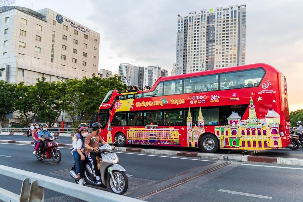 Xe buýt và xe máy lưu thông nhộn nhịp trên đường phố Sài Gòn